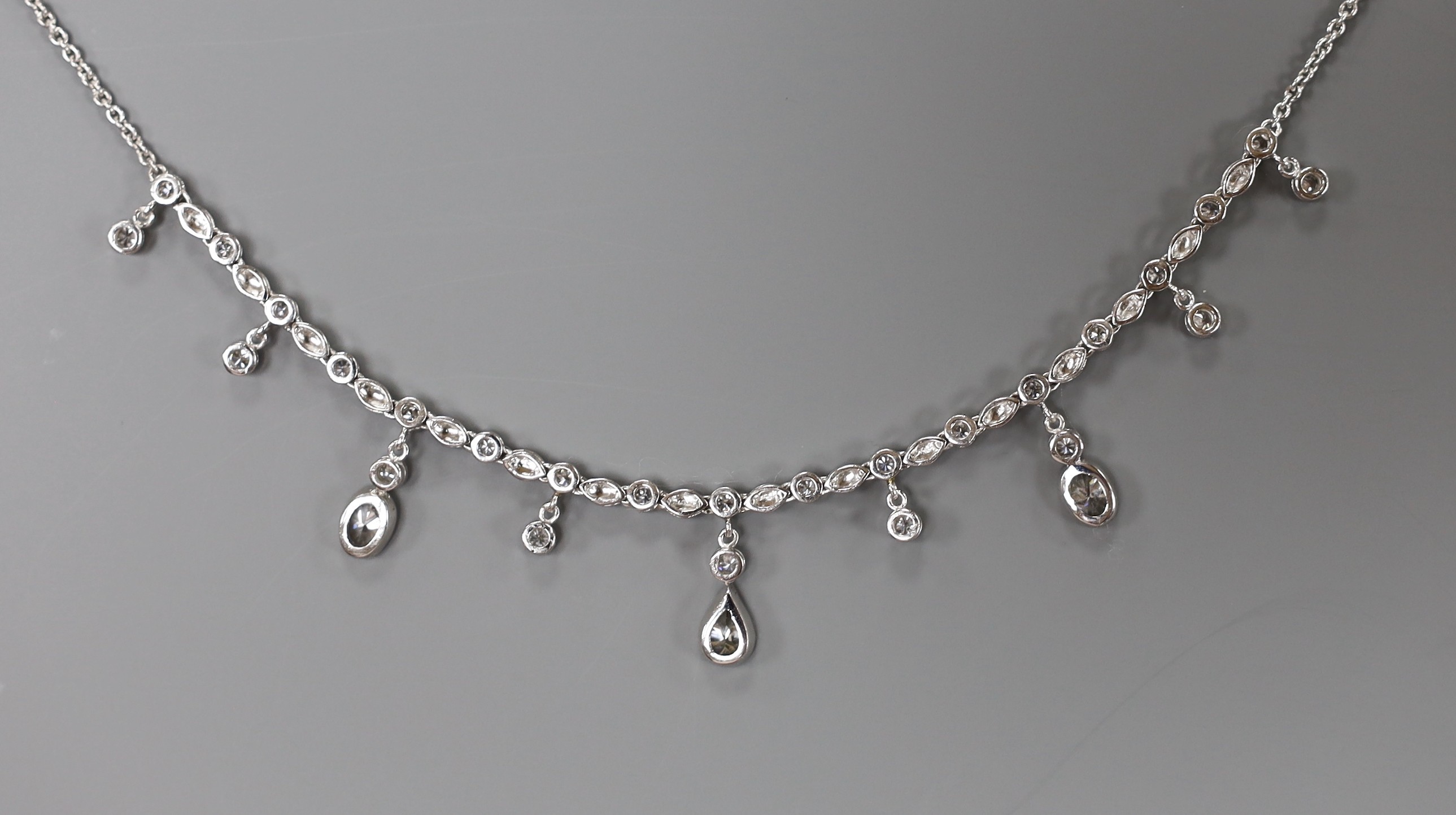 A modern 750 white metal and diamond cluster set drop fringe necklace, 42cm, gross weight 11.8 grams